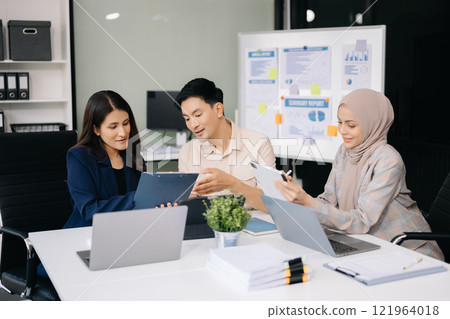 Group of young business people discussing business plan at modern startup in creative business discussing work modern office building 121964018