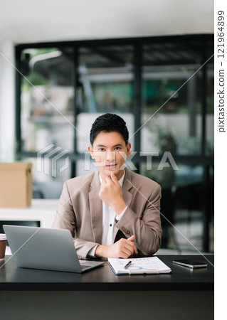 Businessman working at office with laptop, tablet and taking notes on the paper. 121964899