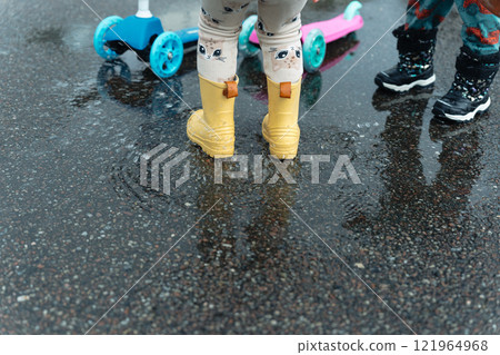 孩子們的雨鞋在水坑裡玩耍 孩子們的雨鞋在水坑裡玩耍 121964968