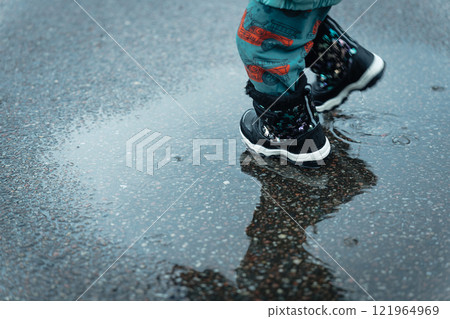 Feet of a boy playing in a puddle 121964969