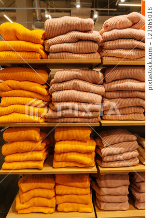 winter sweaters on the store shelf. warm clothes on sale in the showroom 121965018