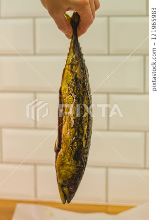Smoked Mackerel:Close-up of Golden-Brown Smoked Mackerel Fish Hanging by Tail. High quality photo 121965983