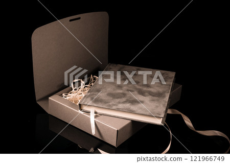 Best gift for men. Man gift concept. Grey notebook with Grey gift box on black background. Copy space text. Valentine's day, wedding, birthday and special occasion gift concept. Copy space for text. Best gift for men. Man gift concept. Grey notebook with Grey gift box on black background. Copy space text. Valentine's day, wedding, birthday and special occasion gift concept. Copy space for text. 121966749