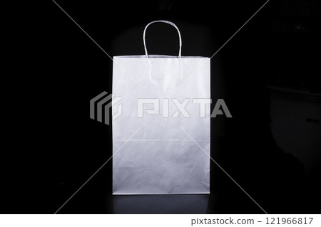 Recyclable craft paper bag for purchases, gifts and takeaway food mock up on black background. Environmentally friendly than single-use plastic bags 121966817