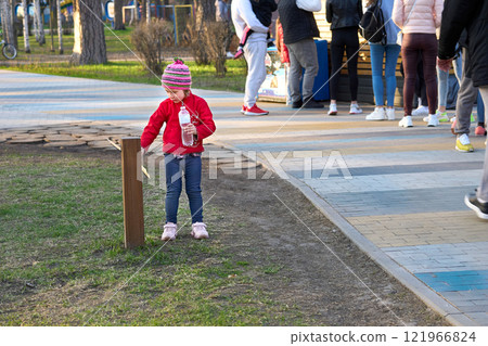 Little girl bottle of mineral water waiting mother buying coffee in kiosk park 121966824