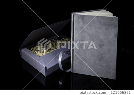 Best gift for men. Man gift concept. Purple notebook with purple gift box on black background. Copy space. Valentine's day, wedding, birthday and special occasion gift concept. Copy space for text. 121966851