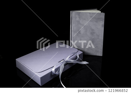 Best gift for men. Man gift concept. Purple notebook with purple gift box on black background. Copy space. Valentine's day, wedding, birthday and special occasion gift concept. Copy space for text. 121966852