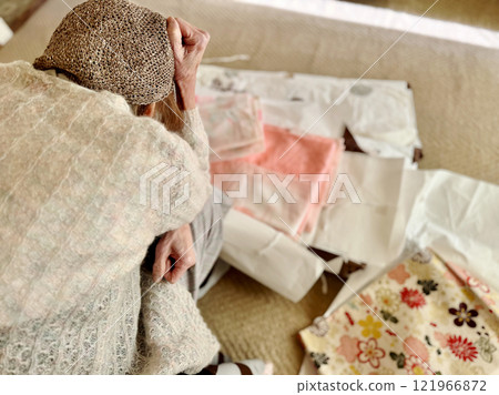 Elderly woman holding her head in front of something Elderly woman holding her head in front of something 121966872