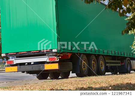 Heavy trailer with a green awning for long distance transportation.Delivery 121967341