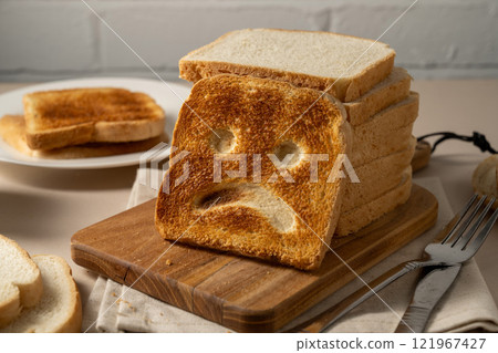 Gluten food, slice of toasted bread with sad face. Gluten allergy 121967427