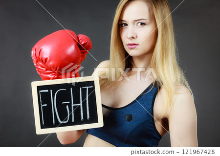 Woman wearing boxing glove holding fight sign 121967428
