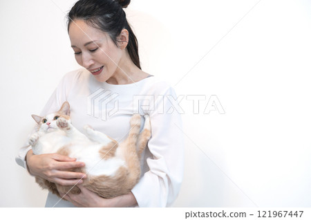 Middle-aged woman holding a cat 121967447