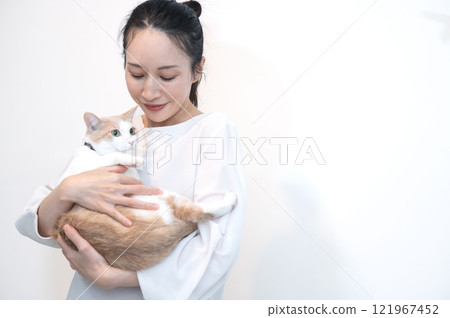 Middle-aged woman holding a cat 121967452