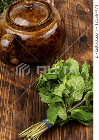 Glass teapot with herbal tea. Glass teapot with herbal tea. 121967471