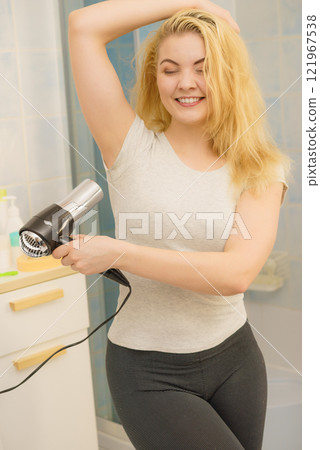 Woman drying sweat stains using hair dryer Woman drying sweat stains using hair dryer 121967538