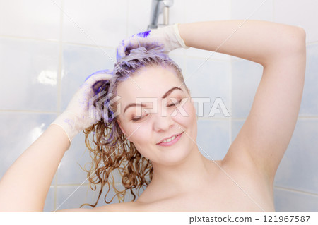 Woman applying toner shampoo on her hair 121967587