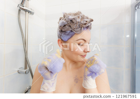 Woman applying toner shampoo on her hair 121967591