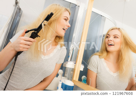 Woman using hair curler 121967608