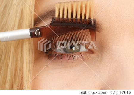 Woman brushing her eyelashes 121967610