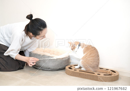 一位中年婦女正在和一隻貓玩耍 一位中年婦女正在和一隻貓玩耍 121967682