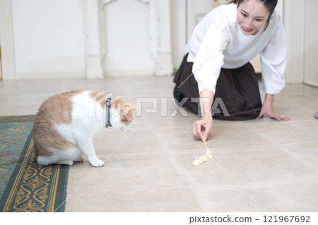 A middle-aged woman playing with a cat A middle-aged woman playing with a cat 121967692