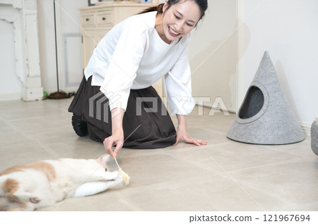 一位中年婦女正在和一隻貓玩耍 121967694