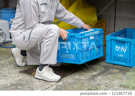 Man in work clothes collecting garbage 121967739