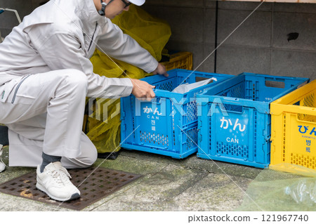 一名穿著工作服的男子在手邊收集垃圾 121967740