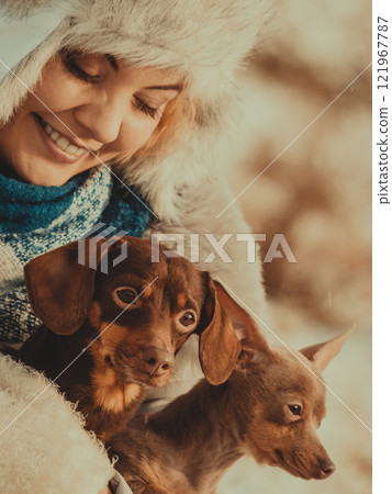 Woman playing with dogs during winter 121967787