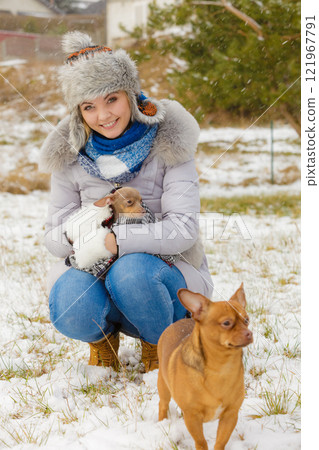 Woman playing with dogs during winter 121967791