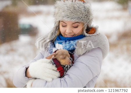 Woman hug warming her little dog in winter 121967792
