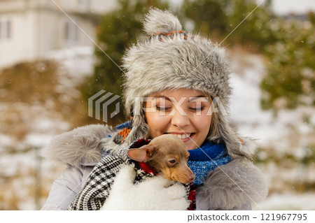 Woman hug warming her little dog in winter 121967795