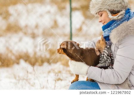 Woman playing with dogs during winter Woman playing with dogs during winter 121967802