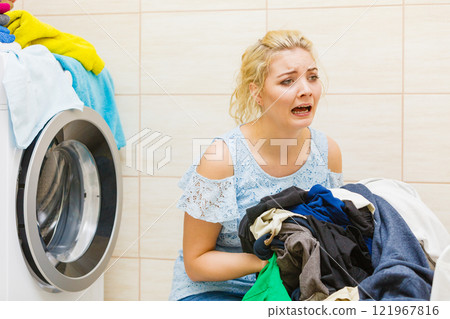 Unhappy girl with dirty clothes laundry. Unhappy girl with dirty clothes laundry. 121967816