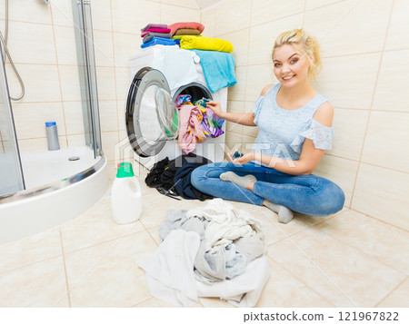 Woman wash laundry using detergent pods Woman wash laundry using detergent pods 121967822