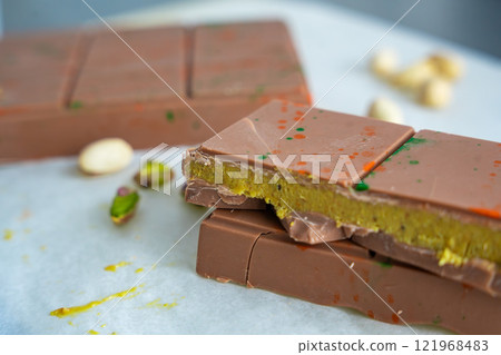 Trend Dubai chocolate with pistachio paste and kataifi dough. Confectionery handmade sweets at home in the kitchen.  121968483