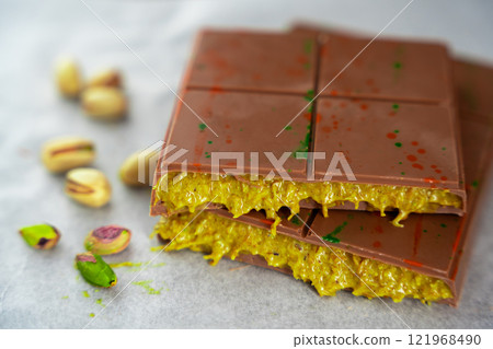 Trend Dubai chocolate with pistachio paste and kataifi dough. Confectionery handmade sweets at home in the kitchen. Trend Dubai chocolate with pistachio paste and kataifi dough. Confectionery handmade sweets at home in the kitchen. 121968490