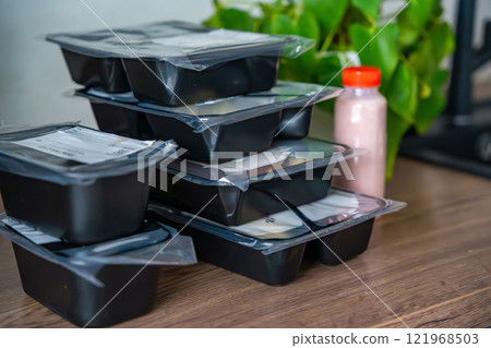 Black boxes with healthy diet plan for weight loss, delivery of daily ready meal menu. Food ordered with mobile phone app. Balanced portion with dish. Pre-cooking. 121968503