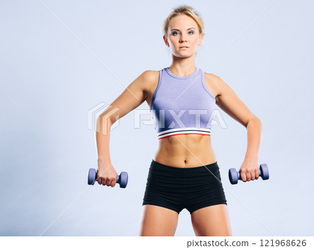 Fit woman lifting dumbbells weights Fit woman lifting dumbbells weights 121968626