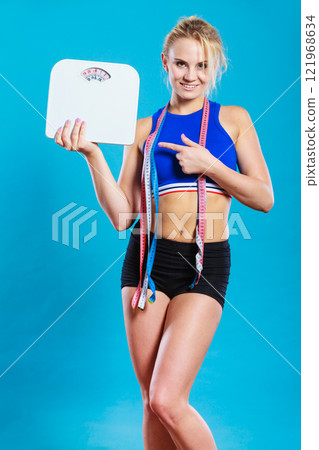 Fit woman with measure tape with weight scale Fit woman with measure tape with weight scale 121968634