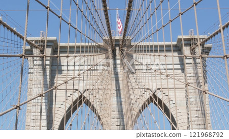 Brooklyn Bridge to Manhattan downtown, cables and blue sky. New York City iconic symbol. Travel USA. Brooklyn Bridge to Manhattan downtown, cables and blue sky. New York City iconic symbol. Travel USA. 121968792
