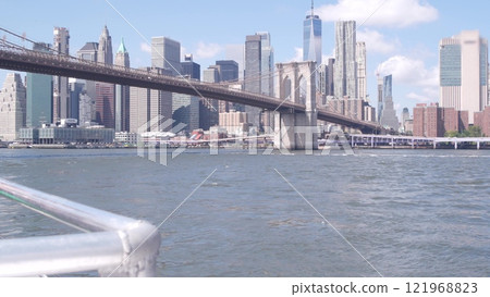 New York City downtown skyline from ferry boat. Manhattan bridge, East river, World Trade Center USA 121968823