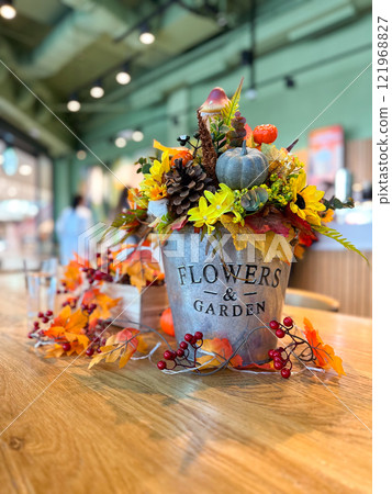 Festive autumn table arrangement with vibrant fall decorations and a miniature pumpkin. Warm tones and cozy ambiance evoke the spirit of the harvest season and Halloween celebrations 121968827