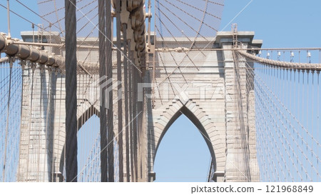 Brooklyn Bridge to Manhattan downtown, cables and blue sky. New York City iconic symbol. Travel USA. 121968849