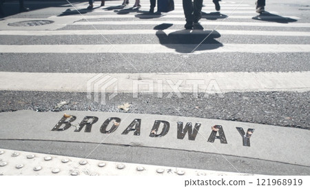 Broadway street sign, people on pedestrian zebra crossroad. New York City Manhattan road intersection Broadway street sign, people on pedestrian zebra crossroad. New York City Manhattan road intersection 121968919