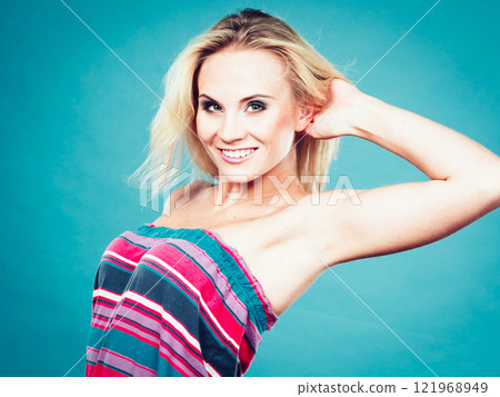 Blonde woman wearing colorful striped strapless shirt 121968949