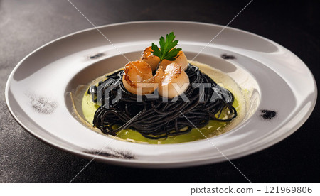 A plate of food with a green sauce and black noodles A plate of food with a green sauce and black noodles 121969806