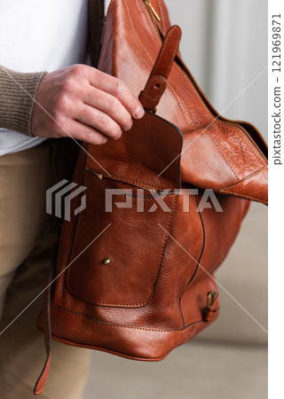 A Stylish and Professional Man Standing with a yellow brown backpack 121969871