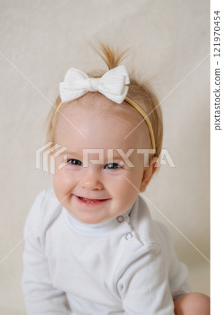 close up of laughing happy child in white clothes, little smiling girl 121970454