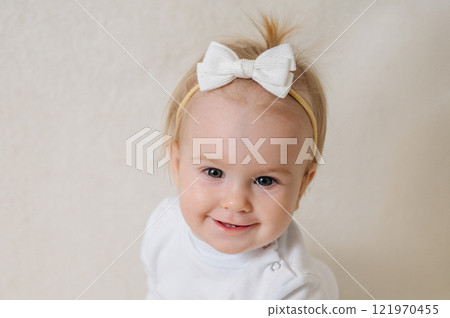close up of laughing happy child in white clothes, little smiling girl 121970455